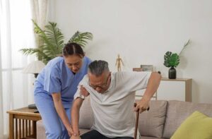 Older adult and family caregiver review a care plan and safety checklist at a kitchen table.